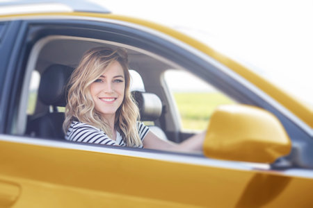 Blonde in the car. Attractive woman drives a car.