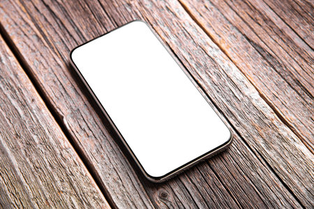 Smartphone with white screen on a background of wooden boards.
