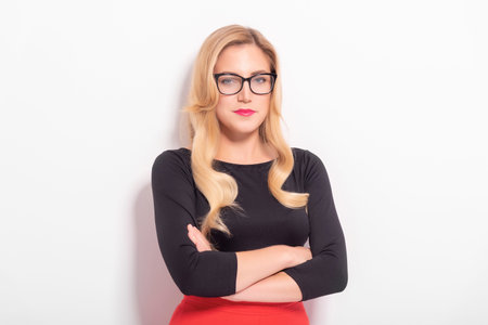 Fashionable young blonde woman in glasses on a white background.の写真素材