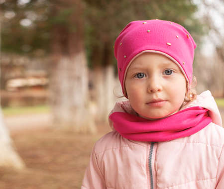 Portrait of a girl. Little girl in warm clothes on the street.の写真素材