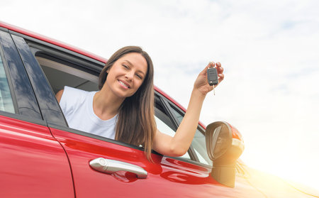 Attractive young woman shows the keys to the car.