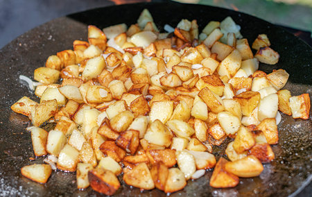 Fried potatoes on a fire or grill.