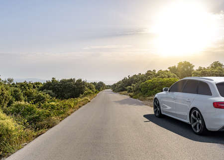 Car is driving along the road. White car on a suburban highway.の写真素材