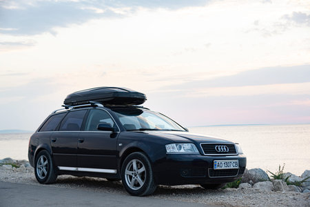 Travelers car Audi A6 on the seashore in the evening.