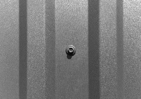 Roofing screw in a profiled sheet close-up.