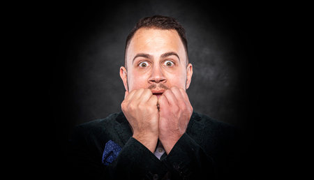 Frightened man on a dark background.