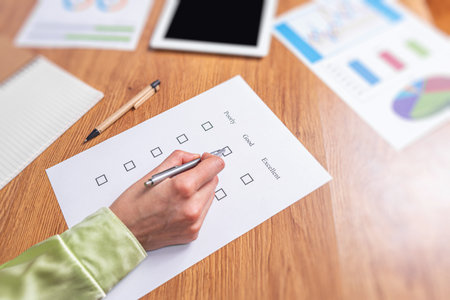 A womans hand fills out a checklist or an exam test giving a mark of good or bad.の写真素材