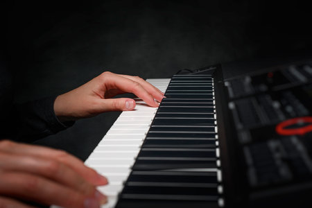 Playing the piano synthesizer on dark backgroundの写真素材