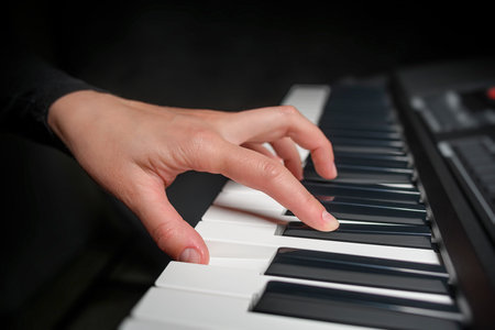 Playing the piano synthesizer on dark backgroundの写真素材