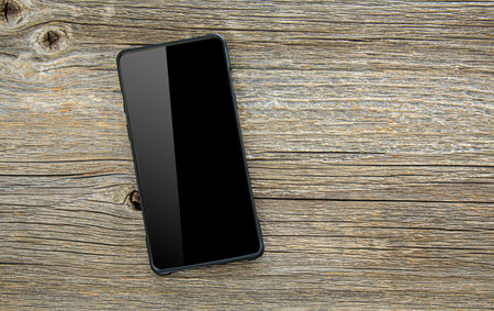 Black smartphone on wooden table.の写真素材