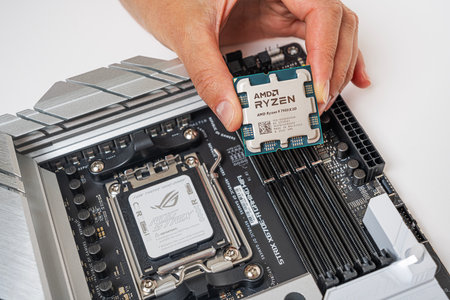 Manual installation of the AMD Ryzen 9 7950X3D processor into the motherboard.のeditorial素材