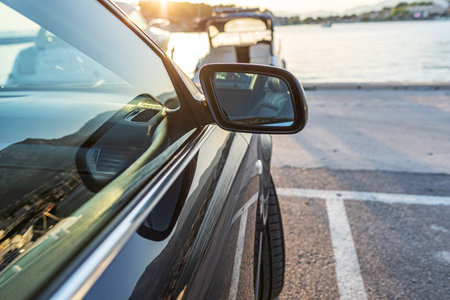 The car is parked on the embankment against the backdrop of the sea.の写真素材