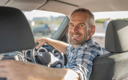 The driver is a young attractive man driving a car.の写真素材
