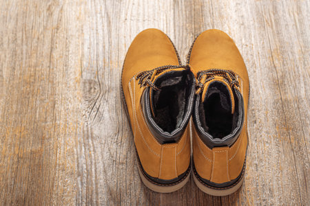 Yellow boots on wooden background.