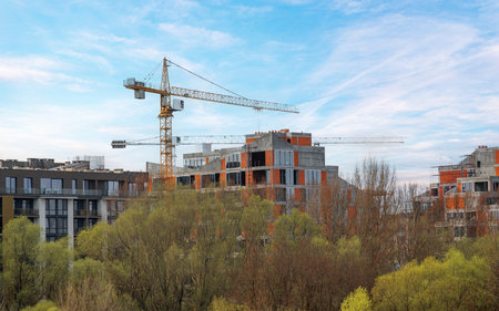 A modern residential complex under construction, featuring concrete and brick structures with large...
