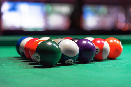A rack of colorful billiard balls on a green pool table felt