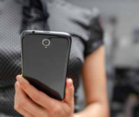 A person is holding a black smartphoneの写真素材