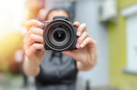 A woman holds a black digital cameraの写真素材