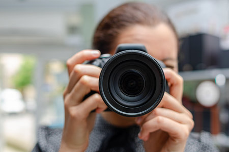 A person holding a black DSLR cameraの写真素材