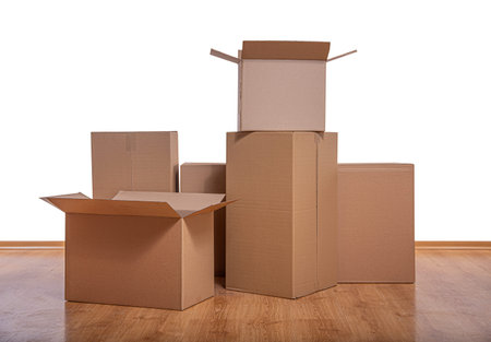 Stack of cardboard boxes on a wooden floor against a white background