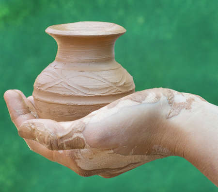Close-up of hand holding pottery an  jarの写真素材