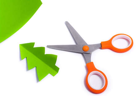 Scissors cut out fir of paper over whiteの写真素材