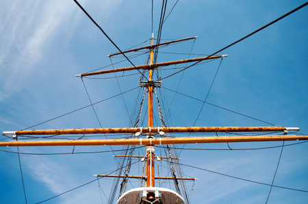 Old mast of a ship with blue sky on background 