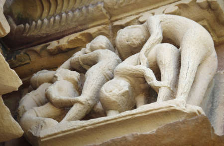 Stone carved erotic bas relief in Hindu temple in Khajuraho, India. の写真素材