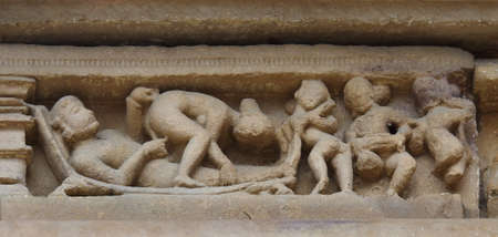 Stone carved erotic bas relief in Hindu temple in Khajuraho, India. の写真素材