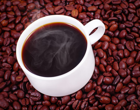 white coffee cup on background brown coffee beans