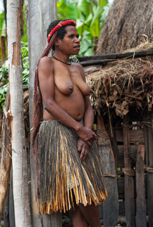 PAPUA PROVINCE, INDONESIA -DEC 28: The woman of a Papuan tribe in traditional clothes and coloring at New Guinea Island, Indonesia on Dec 28, 2010のeditorial素材