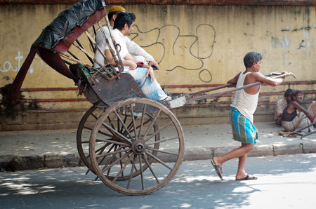 KOLKATA -OCT 06: Traditional hand pulled indian rickshaw driver working on the street on October 10, 2014 in Kolkata, India.のeditorial素材