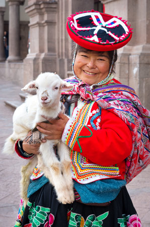 CUSZO, PERU - MARCH 18, 2015: Peruvian woman in traditional dresses pose  for tourists in Cuzco, Peruのeditorial素材