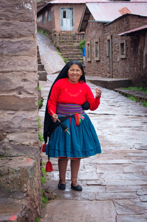TAQUILE, PERU - MARCH 20, 2015: Woman weaving  at Taquile Island in Peruのeditorial素材