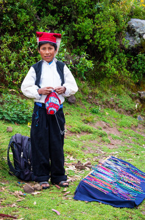 TAQUILE, PERU - MARCH 20, 2015: Boy knitting a hat the traditional way at Taquile Island in Peruのeditorial素材