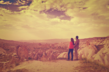 Couple of hikers enjoying valley view in Cappadocia, Turkey, Instagram Effect