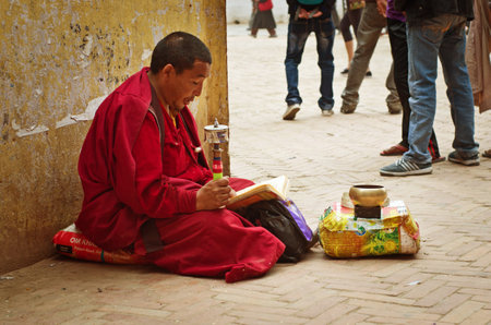 KATHMANDU, NEPAL - CIRCA APR : Tibetan monk near Bodhnath stupa on Apr, 2014 in Kathmandu. Bodhnath stupa is center of Buddhism pilgrimage in Nepal.のeditorial素材