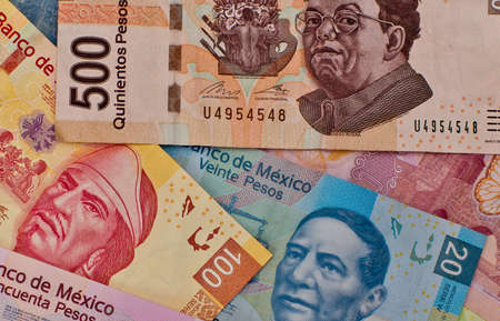 Different Mexican money bills stacked over each other forming a money background.の写真素材