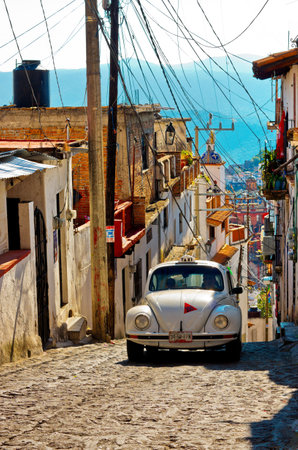 Taxco, Mexico - November 19, 2016: Architecture and taxi (Volkswagen Beetle) of Taxco, Mexico.のeditorial素材