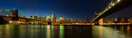 Panoramic view of Manhattan and Brooklyn Bridges from Brooklyn at night. Cityscape of New Yorkの写真素材