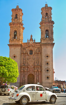 Taxco, Mexico - November 19, 2016: Mini taxi (Volkswagen Beetle) against the Cathedral of Taxco, Mexico.のeditorial素材