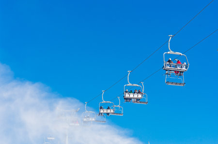Bukovel, Ukraine - December 31, 2015: Skiers and snowboarders on a ski lift in Bukovel. Bukovel is the most popular Ukranian mountain resort.のeditorial素材