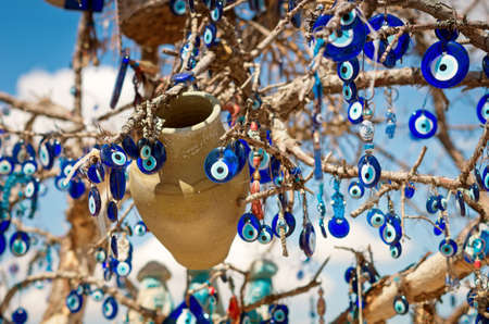 A nazar, charms to ward off the evil eye , on the branches of a tree in Cappadocia, Turkeyの写真素材