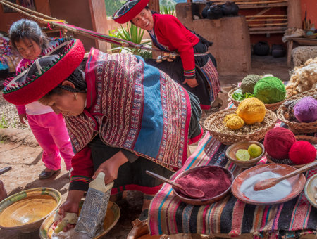 Chinchero, Peru - March 9, 2015: Peruvian woman dressed in traditional clothes while working on a homemade wool industry using traditional techniques.のeditorial素材