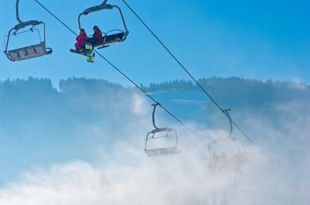 Bukovel, Ukraine - December 31, 2015: Skiers and snowboarders on a ski lift in Bukovel. Bukovel is the most popular Ukranian mountain resort.のeditorial素材