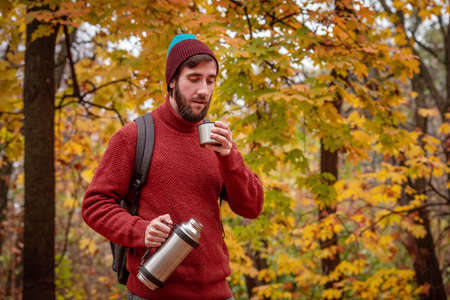 handsome bearded man with cup of tea in the park.の写真素材