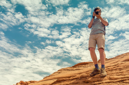 Photographer in mountains against sky