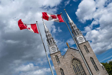 Canadian flags in the forefront of the Notre-Dame Cathedral Basilica in Ottawa. Canadaの写真素材