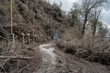 Tengger Caldera, East Java, Indonesia 13 January 2011: Motorcyclist on the destroyed road near Mount...