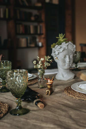 Indoor vintage composition of wildflowers, some dishes and sculpture headの写真素材